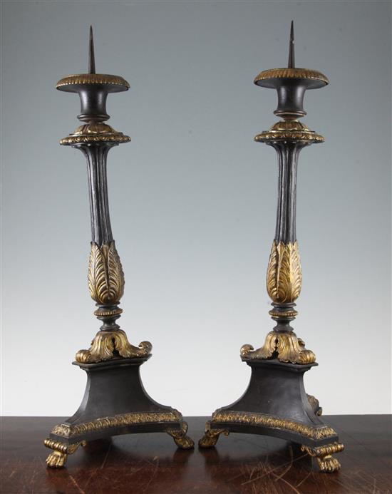 A pair of French Empire style patinated bronze and ormolu pricket candlesticks, 21in.